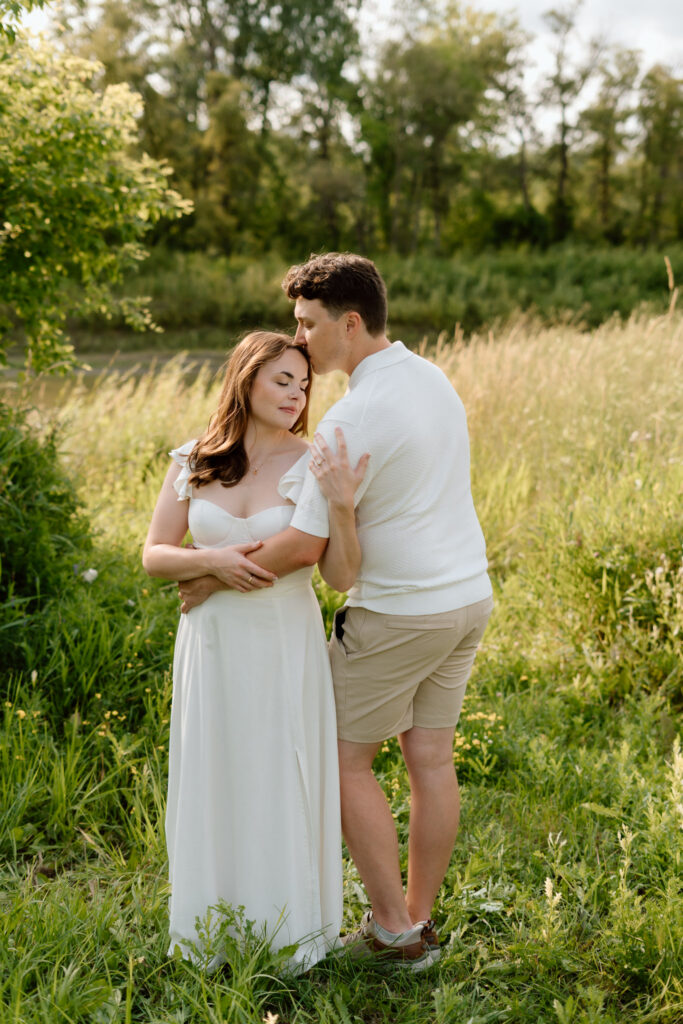 Couple embracing in golden summer light during Miss Millie’s Flower Farm engagement session in Manitoba.