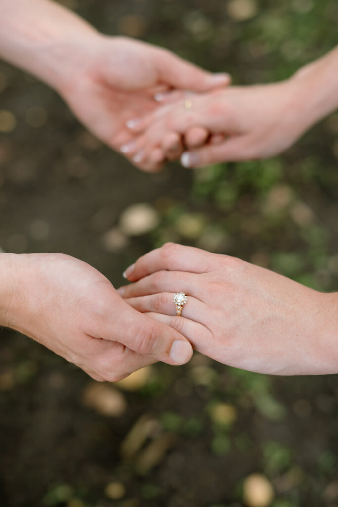Close-up of engagement ring on bride-to-be’s hand during Miss Millie’s Flower Farm engagement session in Manitoba.