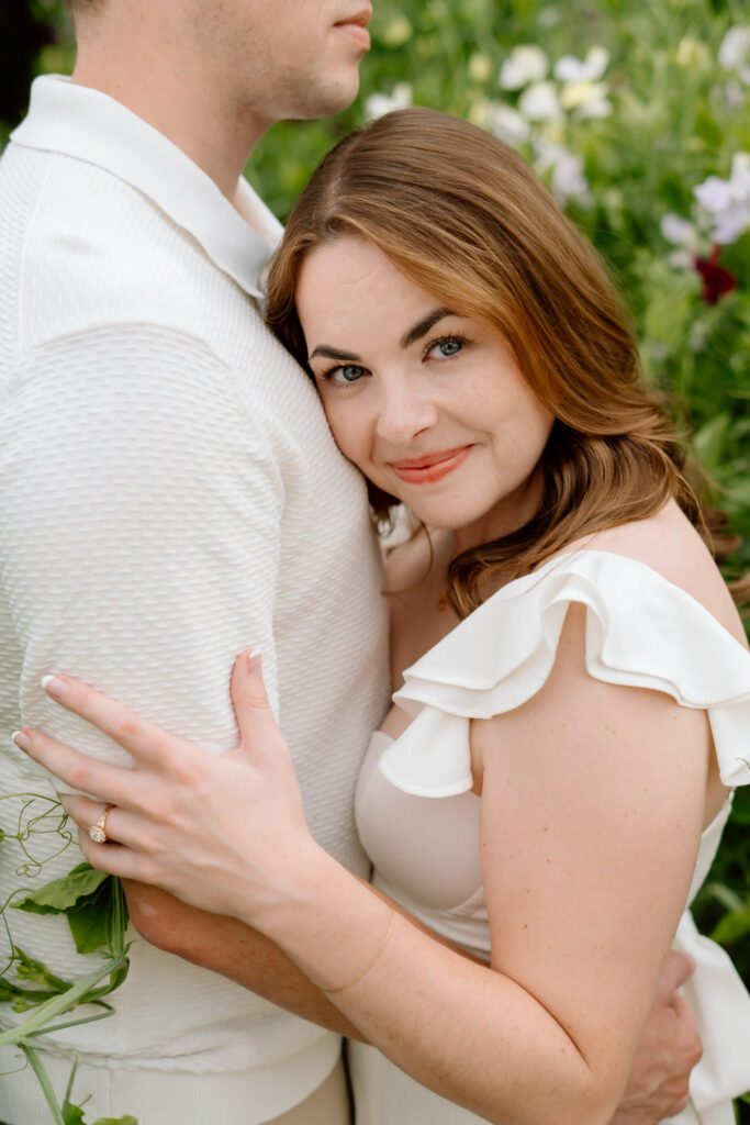 Close-up portrait of couple embracing during Miss Millie’s Flower Farm engagement session in Manitoba surrounded by summer flowers.
